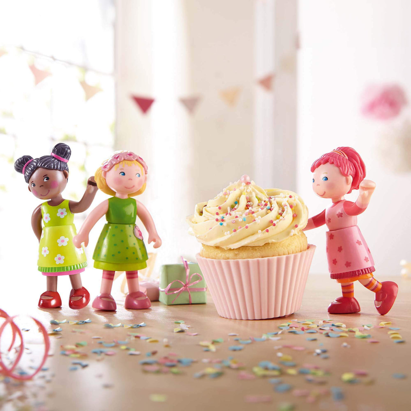 Little Friends dolls with cupcake on wooden table