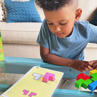 Boy playing Happy Worms by placing a pink wooden worm on the template