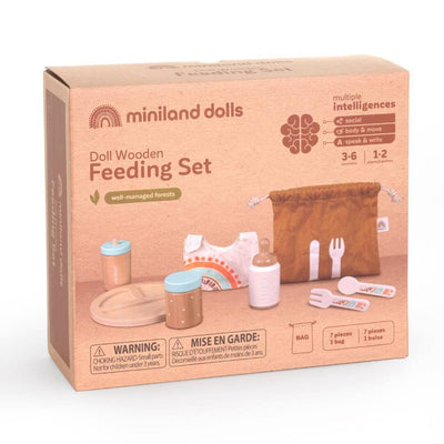 Thebox image of the beautifully crafted wooden doll feeding set by Miniland, made from FSC-certified sustainable wood. The box shows the contents and shows the ages and choking hazard warning. It also show that the set includes a plate, utensils, baby bottle, food jar, bib, and washcloth in soft, natural tones.