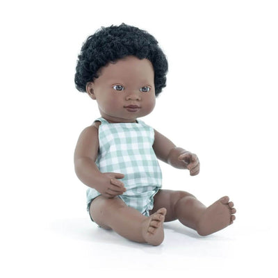 Miniland Realistic Montessori Black boy doll with curly hair, wearing a blue gingham romper, seated on a white background.