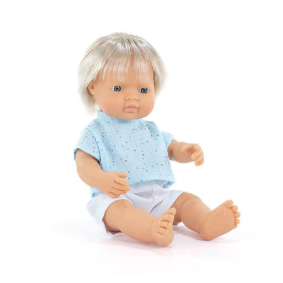 A realistic white boy doll with blond hair, wearing a light blue short-sleeved outfit, sitting upright on a white background.