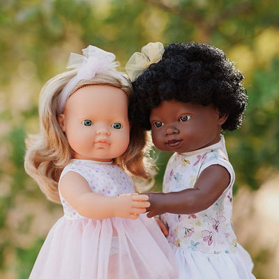 Two Miniland realistic Montessori dolls,  standing together outdoors.