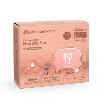 The packaging for the wooden doll beauty set by Miniland, made from FSC-certified sustainable wood. Includes a mirror, brush, hairdryer, makeup compact, lipstick, and carrying case in soft, natural tones.