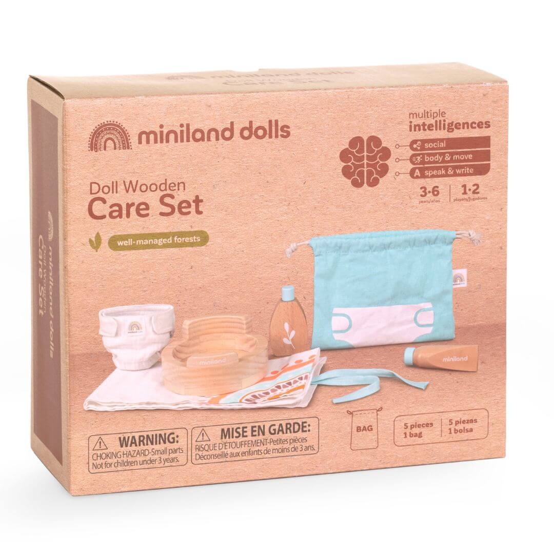 The box that this wooden doll care set by Miniland comes in, featuring a doll potty, wooden lotion bottle, soap, fabric changing mat, washcloth, and a storage bag, made from FSC-certified sustainable wood for nurturing pretend play.