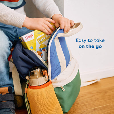 Child's hands zipping a colorful bag with My Very First Games To Go - Pete Ahoy! tucked inside. Text reads 'Easy to take on the go'