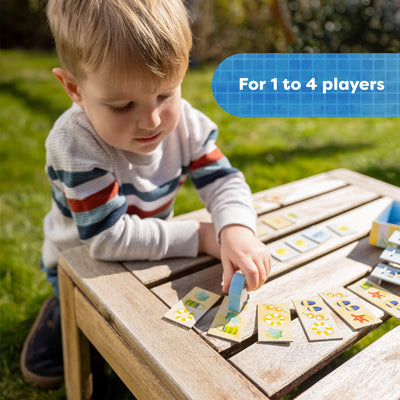 Child playing with My Very First Games To Go - Pete Ahoy! outdoors on a wooden table. Text reads 'For 1 to 4 players'