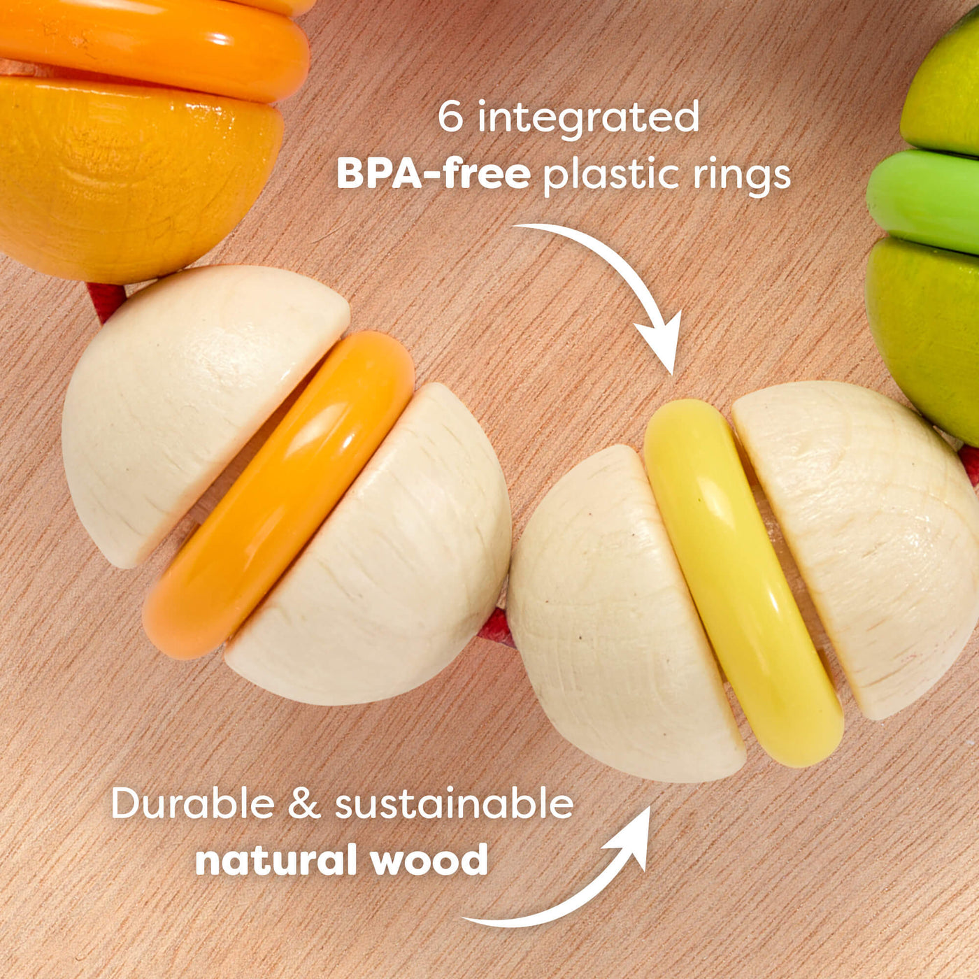 Rainbow Rattle Grasping and Teething Toy  on a wooden surface with text reading '6 integrated BPA-free plastic rings. Durable and sustainable natural wood'