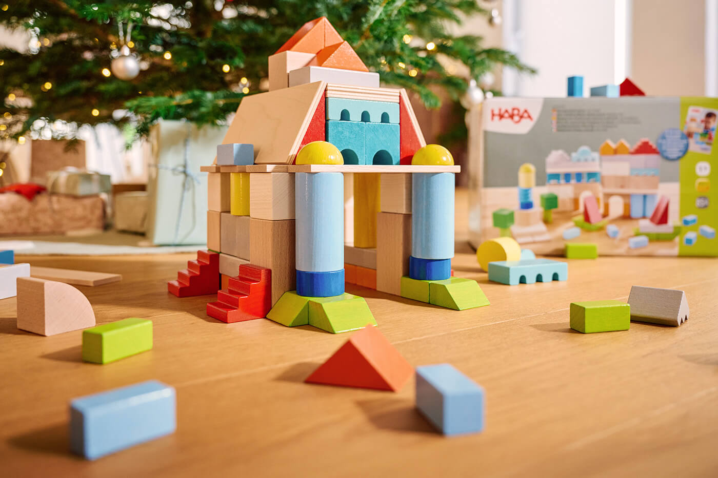 HABA Colorful wooden block structure resembling a castle. Christmas tree and toy box in the background.