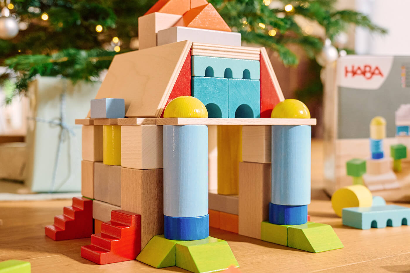 HABA Colorful wooden block structure resembling a castle. Christmas tree and toy box in the background.