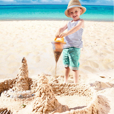 Child at beach playing with HABA Spilling Funnel Sandy Toy