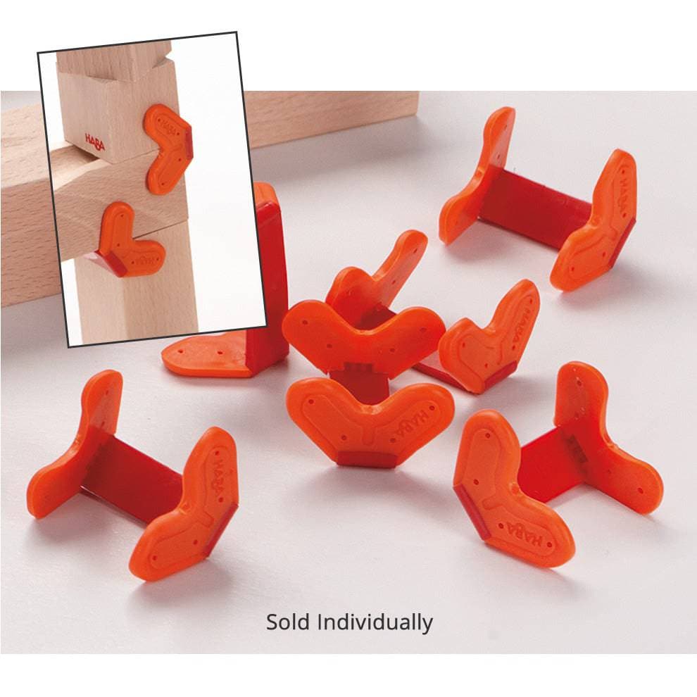 Single Clamp - HABA USA. Close-up of HABA Marble Run Clamps – bright orange stabilizing clips designed to secure wooden marble track systems and block towers for added durability and sturdiness.